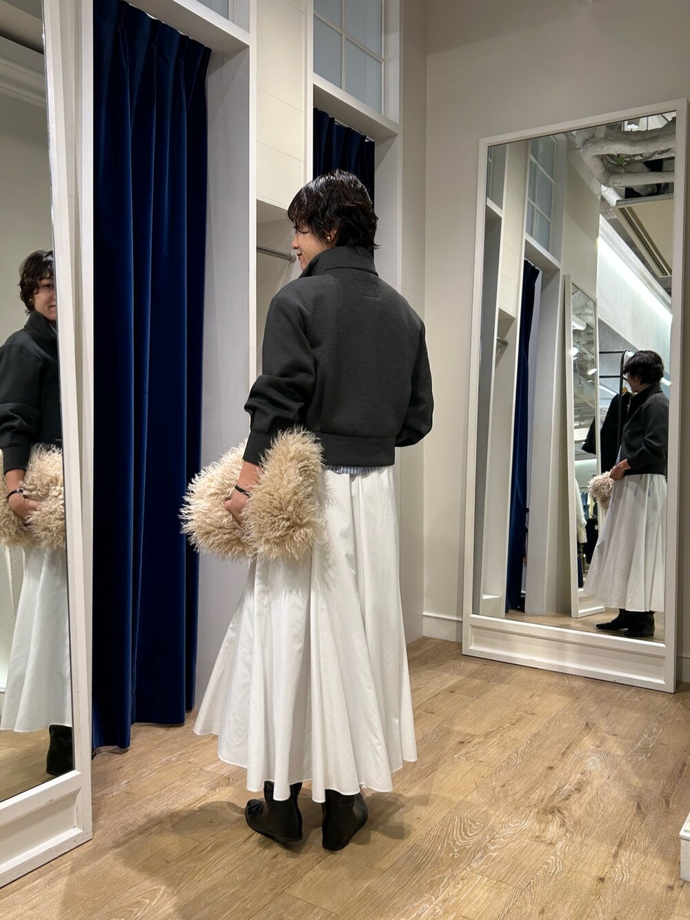 グレー系のブルゾン、ブルー系のシャツ/ブラウス、ホワイト系のスカートを着用したレディースの秋コーディネートの6枚目の写真