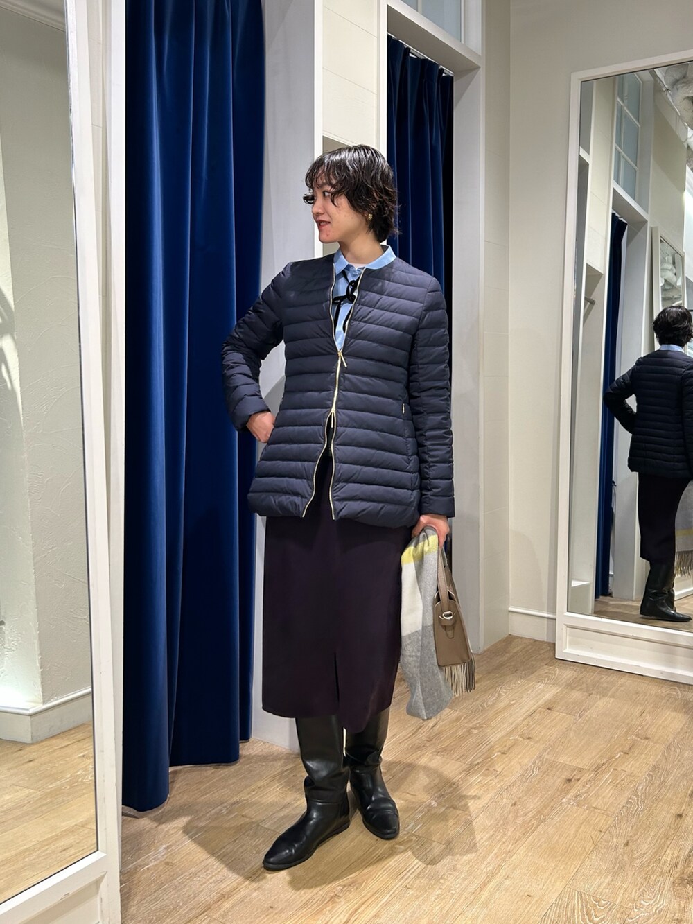 ブルー系のシャツ/ブラウス、ブルー系のダウンジャケット/コート、ブルー系のスカートを着用したレディースの秋コーディネートの3枚目の写真