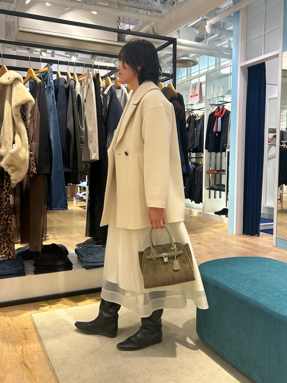 ホワイト系のスカート、イエロー系のニット/セーター、グリーン系のトートバッグを着用したレディースの冬コーディネートの8枚目の写真