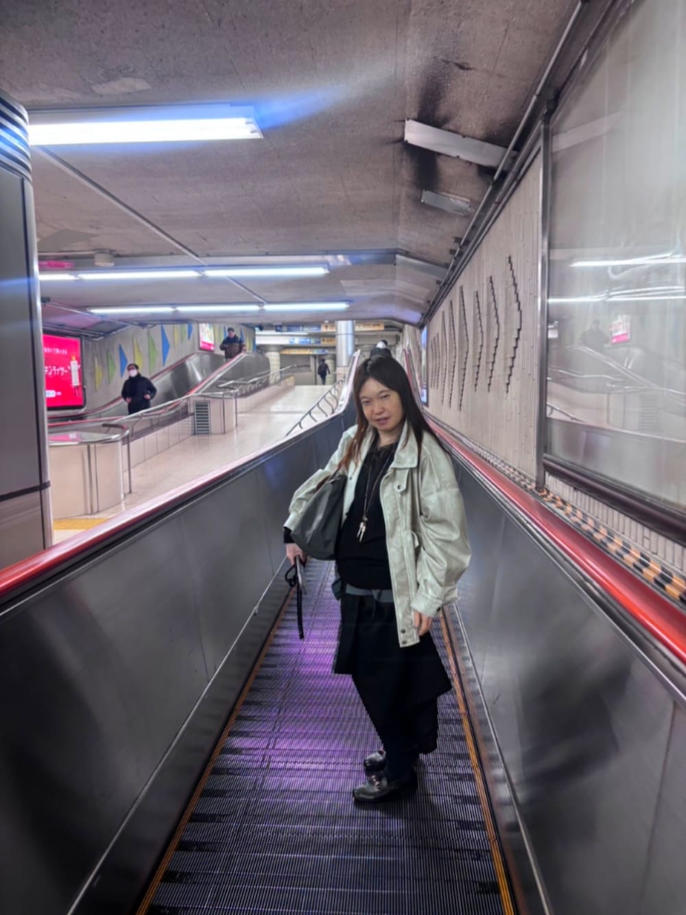 ホワイト系のブルゾン、ブラック系のニット/セーター、シルバー系のネックレスを着用したレディースの冬コーディネートの2枚目の写真