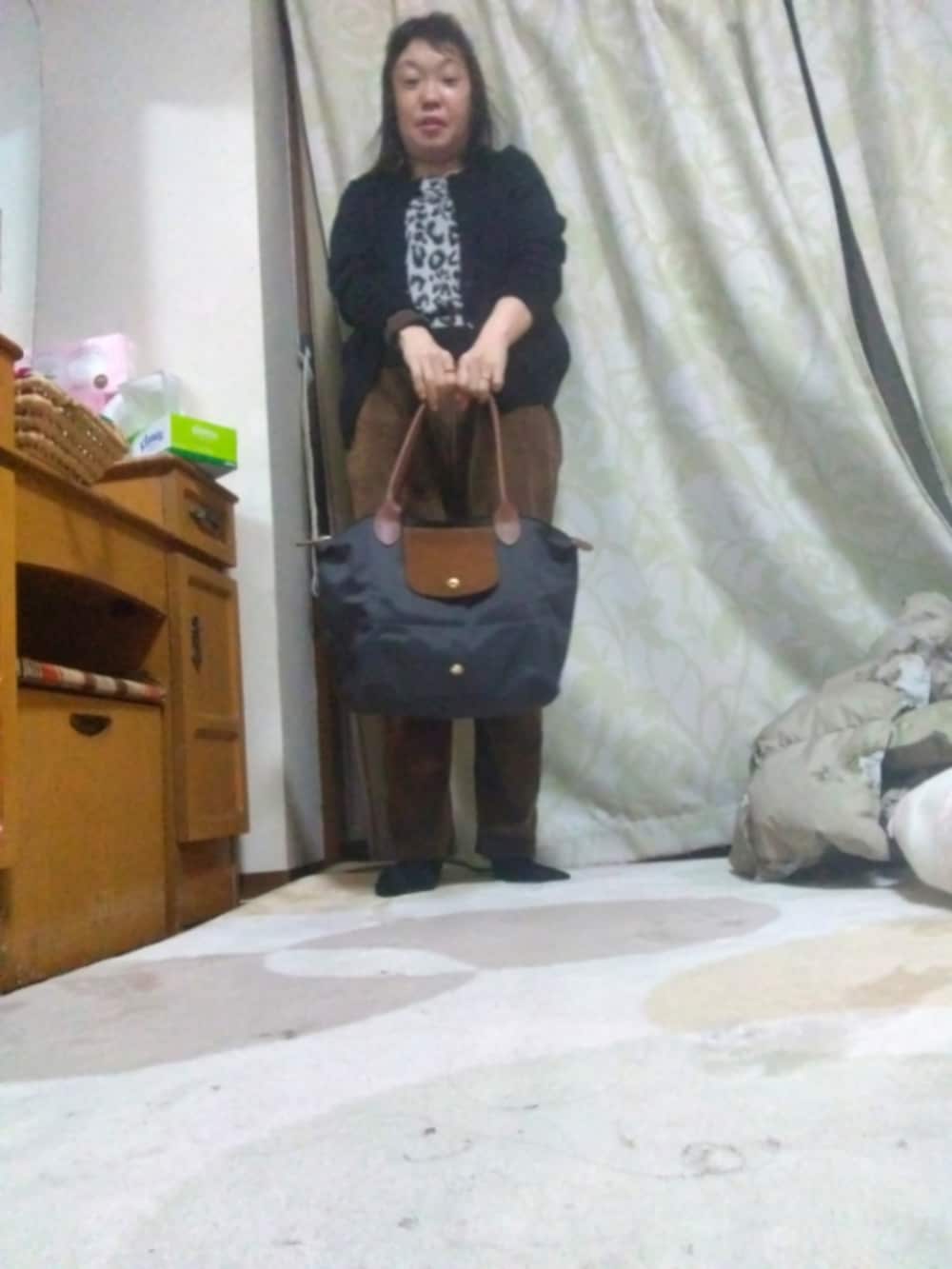 ホワイト系のトップス、ブラック系のカーディガン/ボレロ、グレー系のトートバッグを着用したレディースの冬コーディネートの2枚目の写真