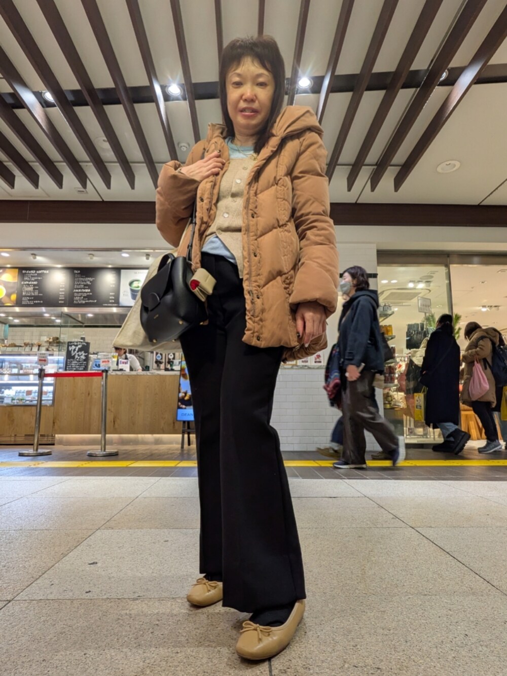 ベージュ系のトップス、ブラック系のその他パンツ、ブラック系のショルダーバッグを着用したレディースの冬コーディネートの2枚目の写真