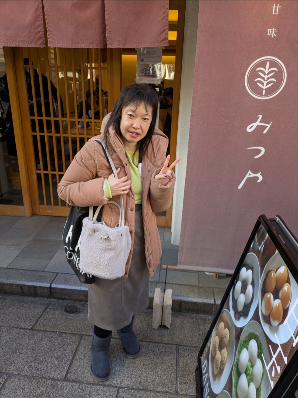 イエロー系のニット/セーター、イエロー系のニット/セーター、ホワイト系のカーディガン/ボレロを着用したレディースの冬コーディネートの3枚目の写真