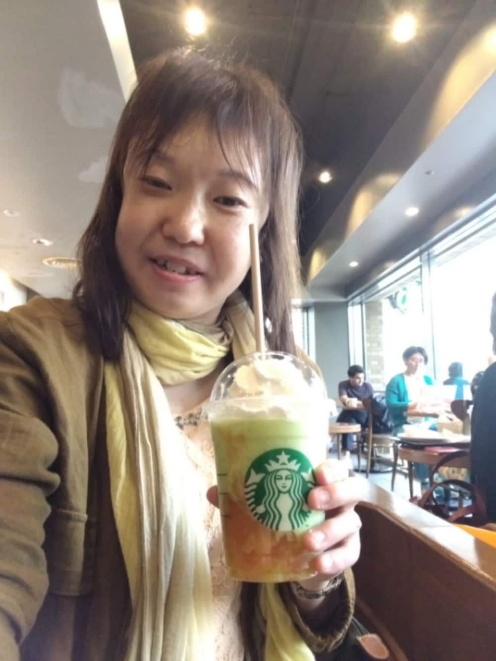 ホワイト系のトップス、ピンク系のチュニック、グレー系のトートバッグを着用したレディースの春コーディネートの2枚目の写真