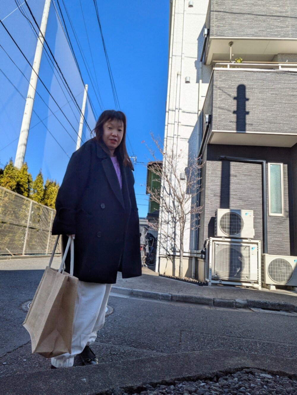 ホワイト系のスウェットパンツ、パープル系のニット/セーター、ブラック系のその他アウターを着用したレディースの冬コーディネートの2枚目の写真