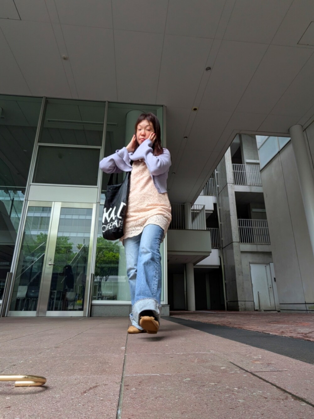 ピンク系のチュニック、ブルー系のデニムパンツ、ピンク系のカーディガン/ボレロを着用したレディースの春コーディネートの2枚目の写真