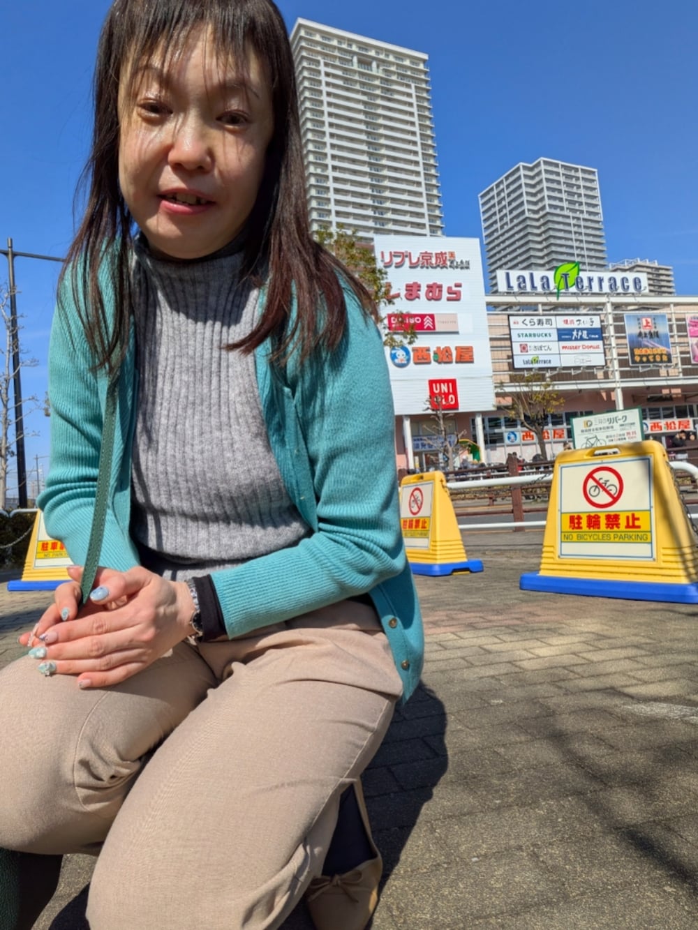 グレー系のニット/セーター、ブルー系のカーディガン/ボレロ、ブルー系のトレンチコートを着用したレディースの春コーディネートの3枚目の写真