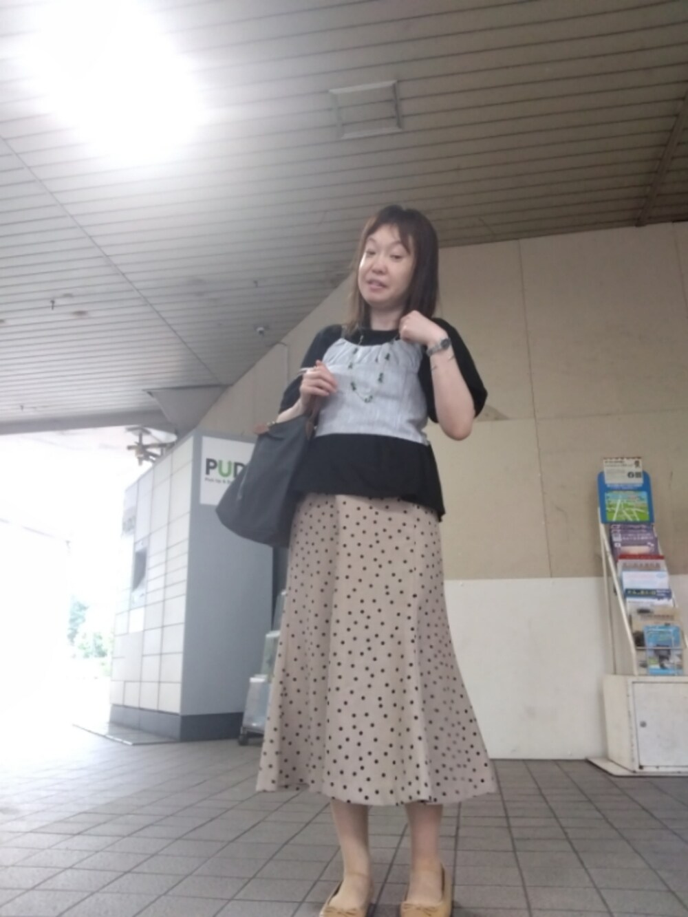 ホワイト系のトップス、ベージュ系のスカート、グレー系のトートバッグを着用したレディースの夏コーディネートの2枚目の写真