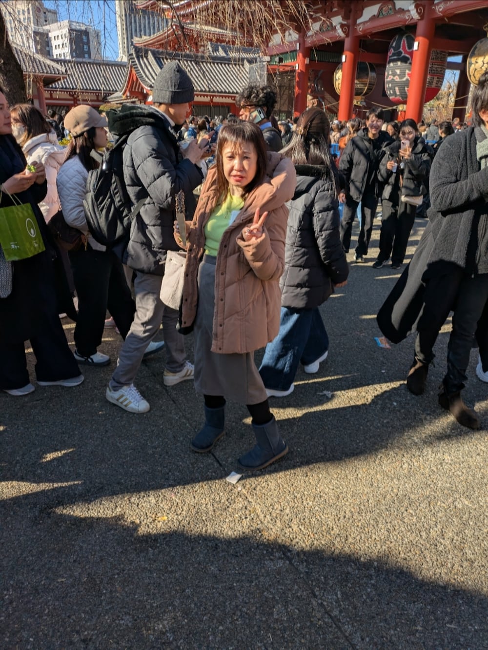 イエロー系のニット/セーター、イエロー系のニット/セーター、ホワイト系のカーディガン/ボレロを着用したレディースの冬コーディネートの2枚目の写真