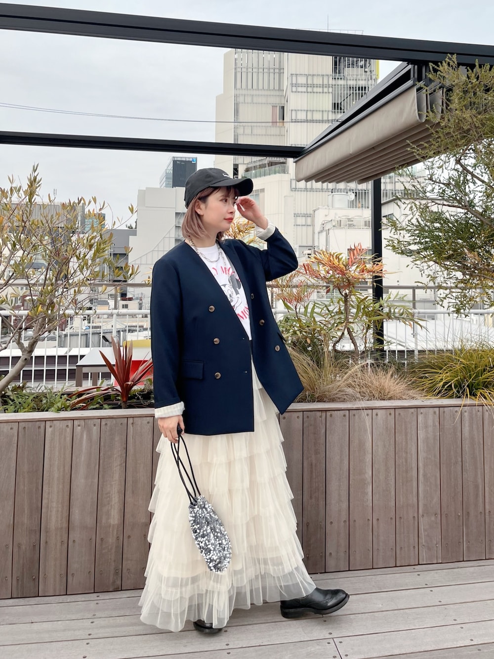 ブルー系のノーカラージャケット、ホワイト系のTシャツ/カットソー、ホワイト系のスカートを着用したレディースの冬コーディネートの3枚目の写真