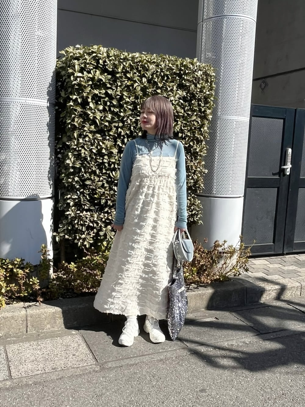 ブルー系のデニムジャケット、ホワイト系のワンピース、ブルー系のTシャツ/カットソーを着用したレディースの春コーディネートの3枚目の写真