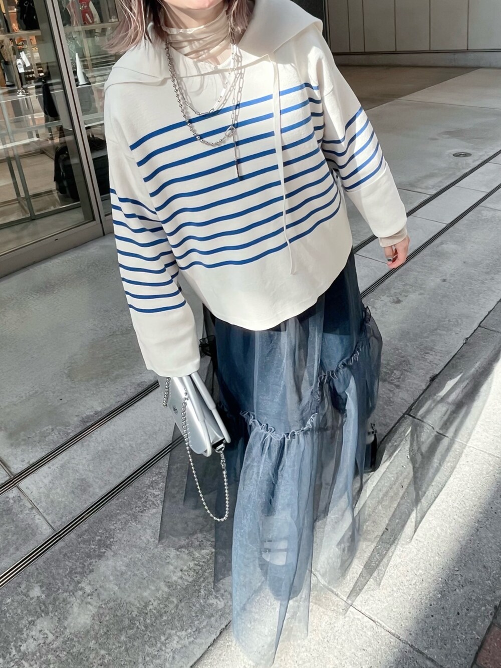 ブルー系のニット/セーター、グレー系のスカートを着用したレディースの冬コーディネートの2枚目の写真