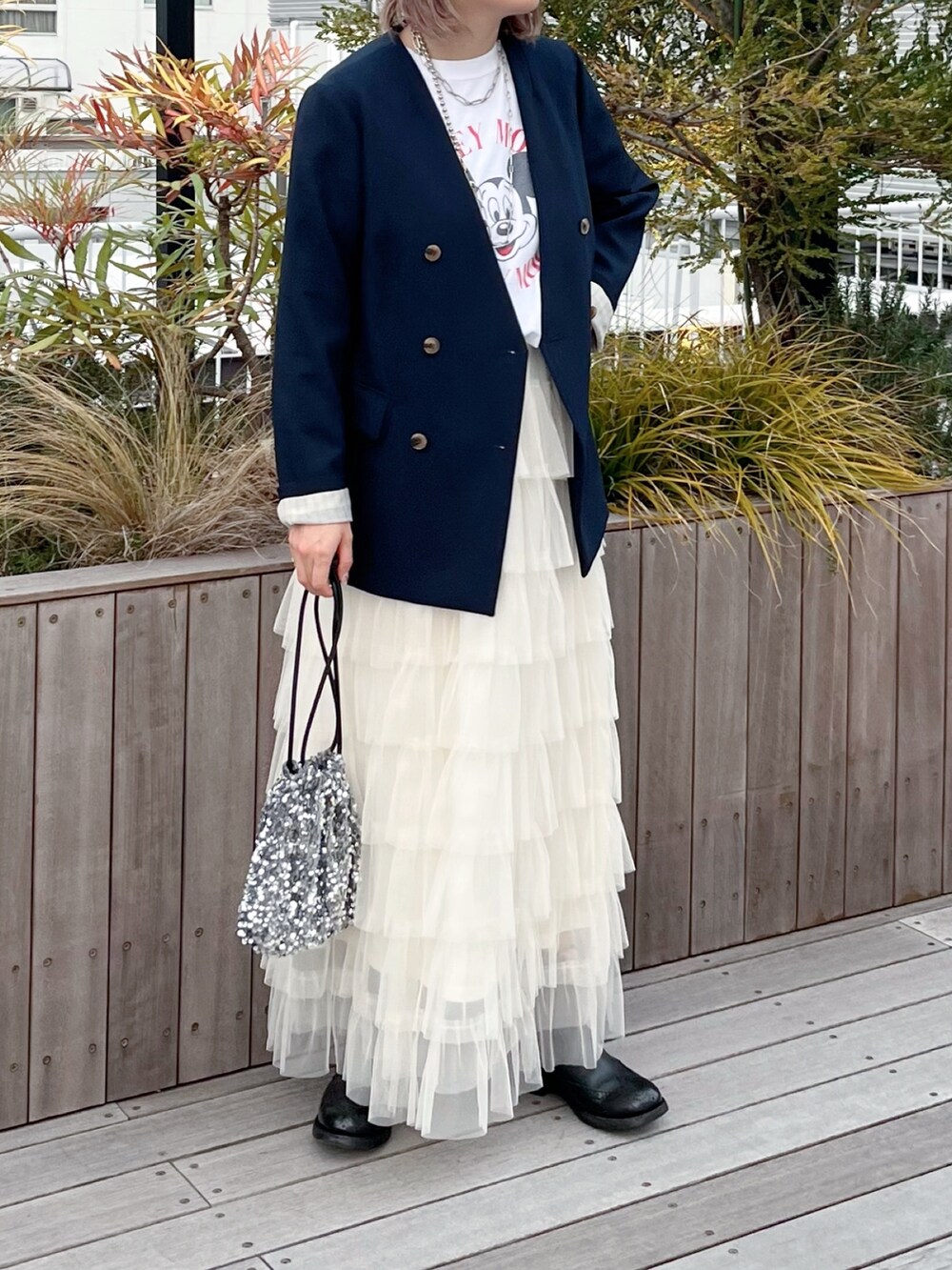 ブルー系のノーカラージャケット、ホワイト系のTシャツ/カットソー、ホワイト系のスカートを着用したレディースの冬コーディネートの2枚目の写真
