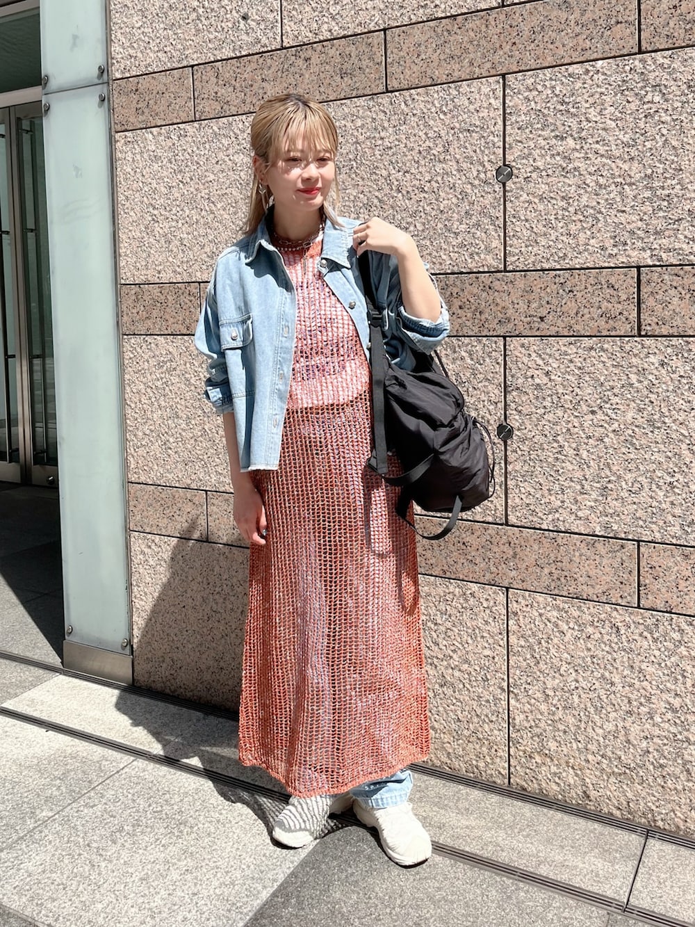 ブラウン系のニット/セーター、ブルー系のシャツ/ブラウス、ブラック系のバックパック/リュックを着用したレディースの春コーディネートの5枚目の写真