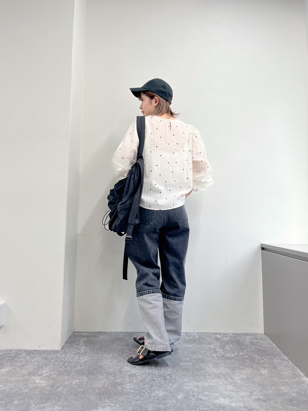 ブラック系のデニムパンツ、ホワイト系のシャツ/ブラウス、ブラック系のキャップを着用したレディースの冬コーディネートの3枚目の写真