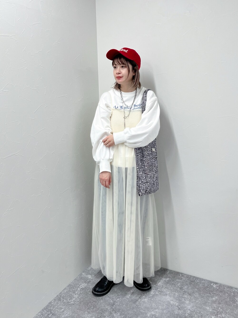 ホワイト系のワンピース、ブルー系のデニムパンツ、ホワイト系のスウェットを着用したレディースの冬コーディネートの3枚目の写真