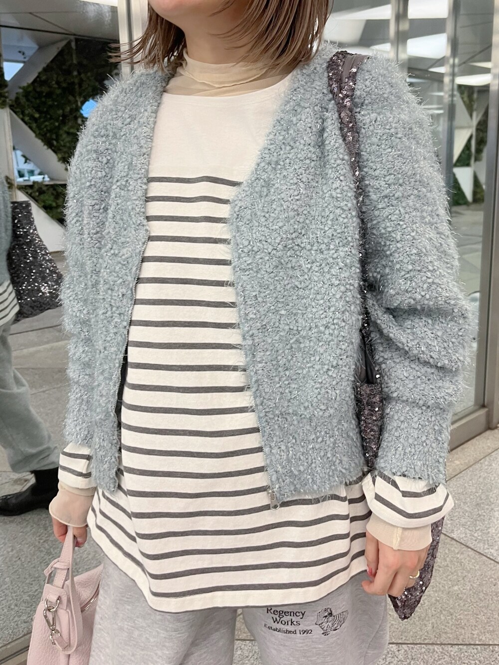 グレー系のTシャツ/カットソー、ブルー系のカーディガン/ボレロを着用したレディースの冬コーディネートの3枚目の写真