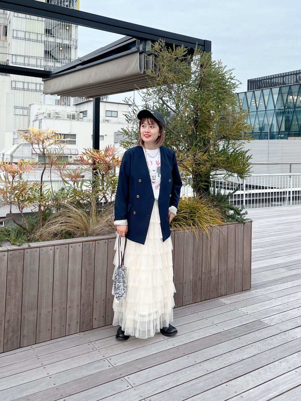 ブルー系のノーカラージャケット、ホワイト系のTシャツ/カットソー、ホワイト系のスカートを着用したレディースの冬コーディネートの6枚目の写真