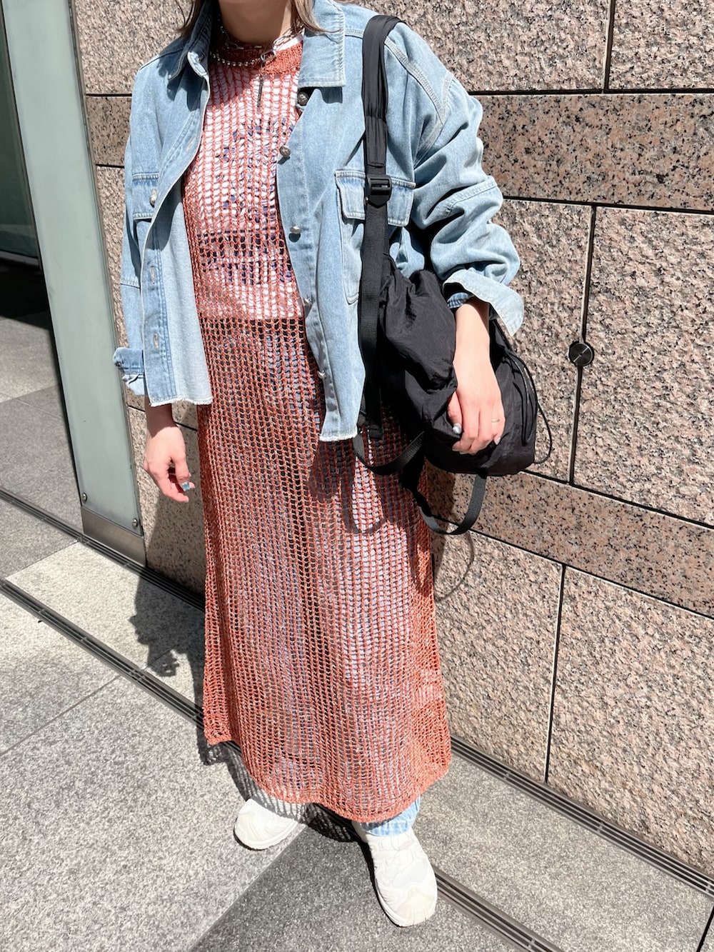 ブラウン系のニット/セーター、ブルー系のシャツ/ブラウス、ブラック系のバックパック/リュックを着用したレディースの春コーディネートの4枚目の写真