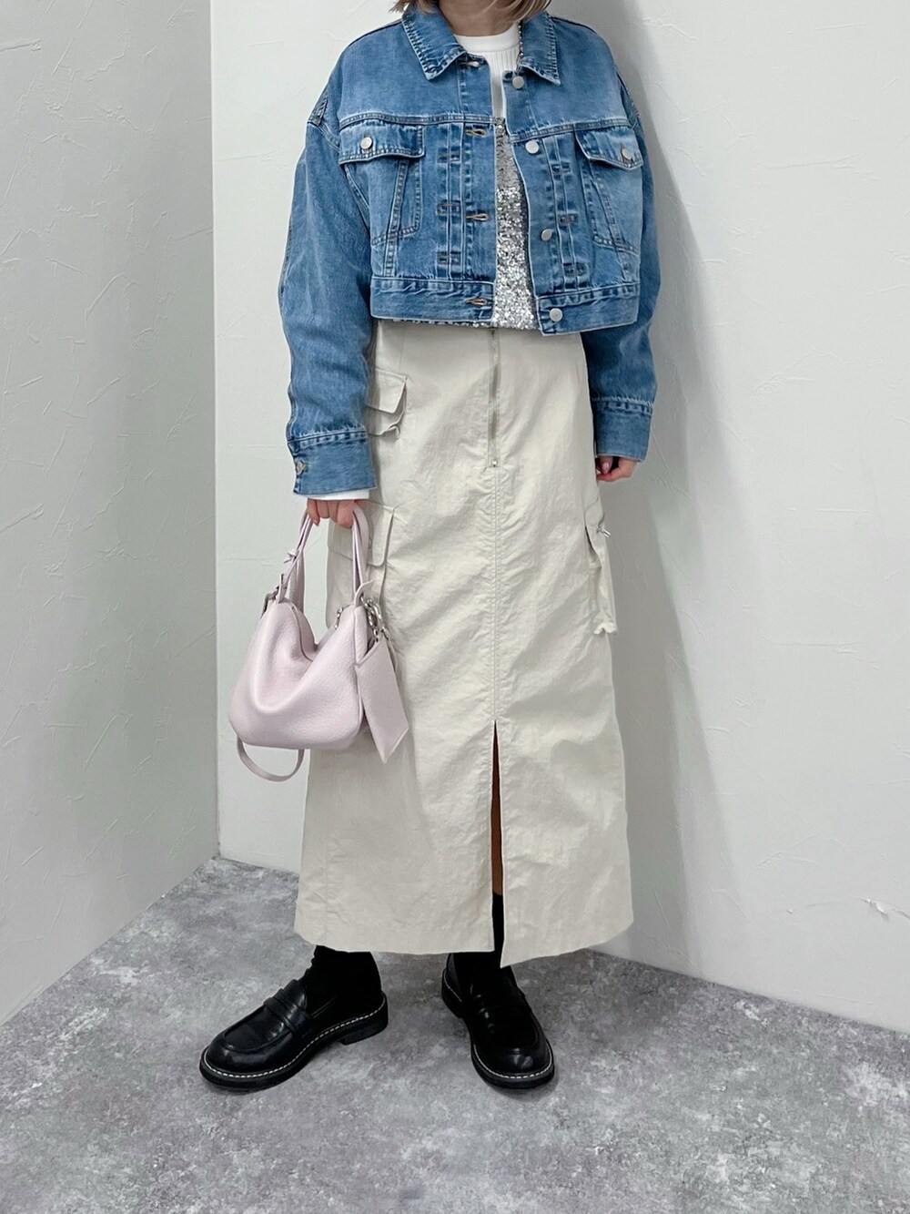 ブルー系のデニムジャケット、シルバー系のシャツ/ブラウス、ベージュ系のスカートを着用したレディースの春コーディネートの2枚目の写真