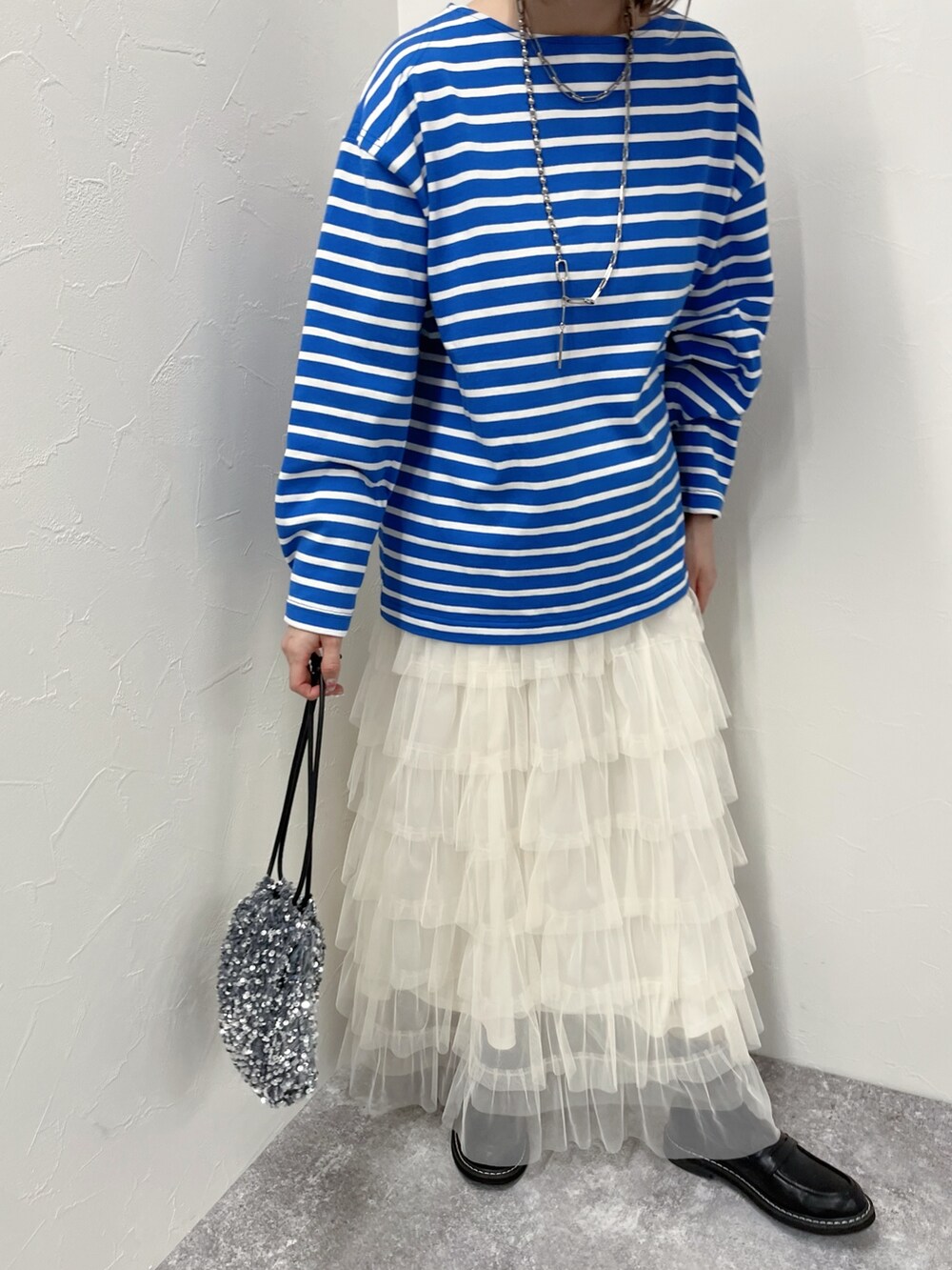 ブルー系のTシャツ/カットソー、ホワイト系のスカート、グレー系のショルダーバッグを着用したレディースの春コーディネートの4枚目の写真