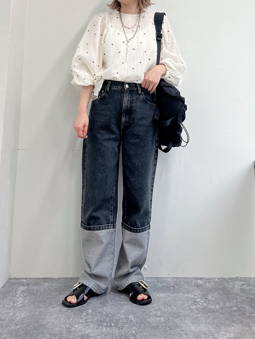ブラック系のデニムパンツ、ホワイト系のシャツ/ブラウス、ブラック系のキャップを着用したレディースの冬コーディネートの2枚目の写真