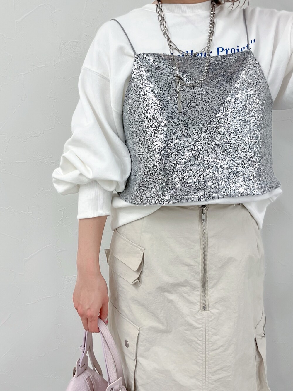 シルバー系のシャツ/ブラウス、ベージュ系のスカート、ホワイト系のスウェットを着用したレディースの春コーディネートの3枚目の写真