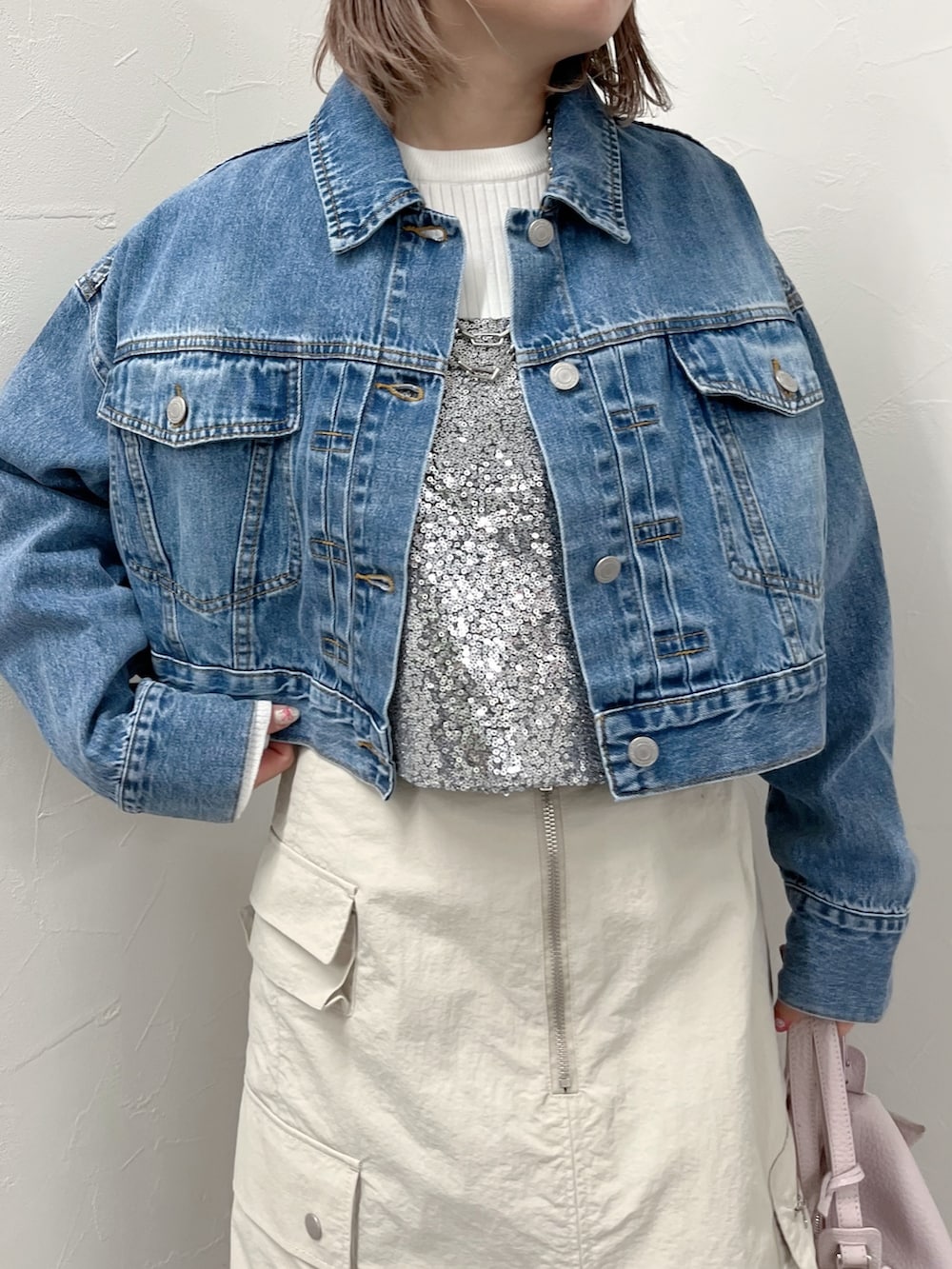 ブルー系のデニムジャケット、シルバー系のシャツ/ブラウス、ベージュ系のスカートを着用したレディースの春コーディネートの4枚目の写真