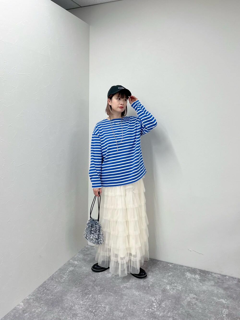 ブルー系のTシャツ/カットソー、ホワイト系のスカート、グレー系のショルダーバッグを着用したレディースの春コーディネートの3枚目の写真