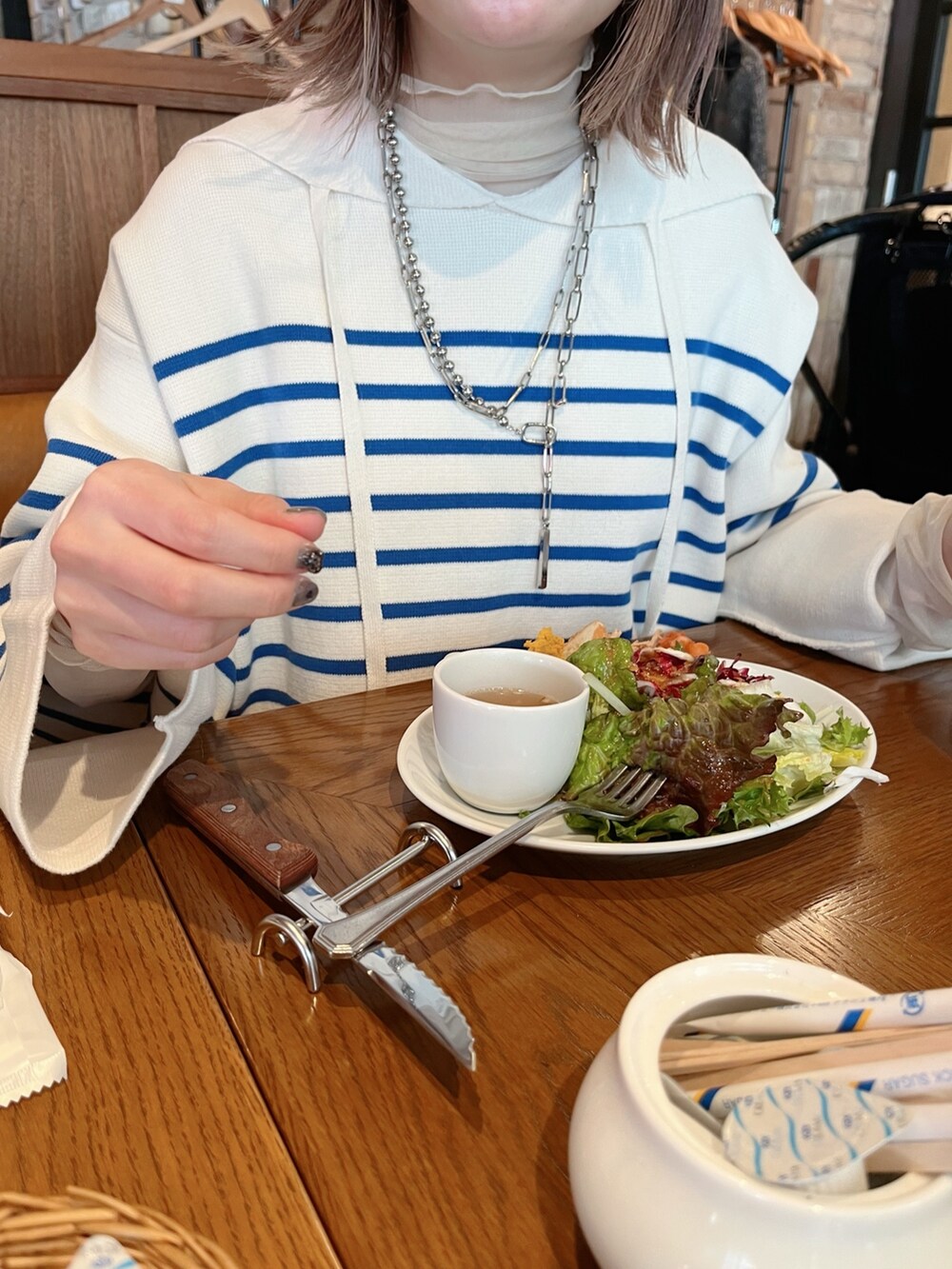 ブルー系のニット/セーター、グレー系のスカートを着用したレディースの冬コーディネートの4枚目の写真