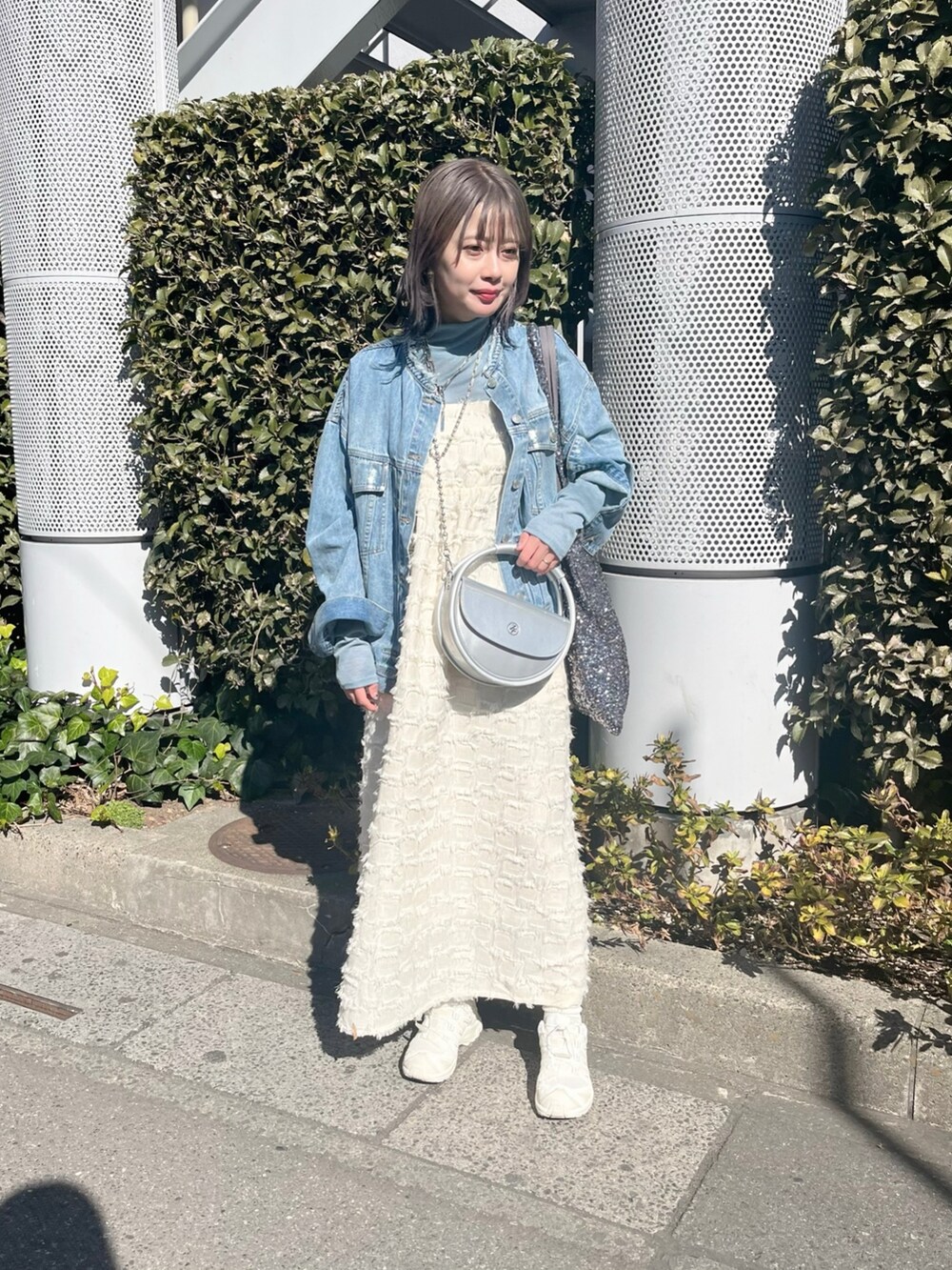 ブルー系のデニムジャケット、ホワイト系のワンピース、ブルー系のTシャツ/カットソーを着用したレディースの春コーディネートの7枚目の写真