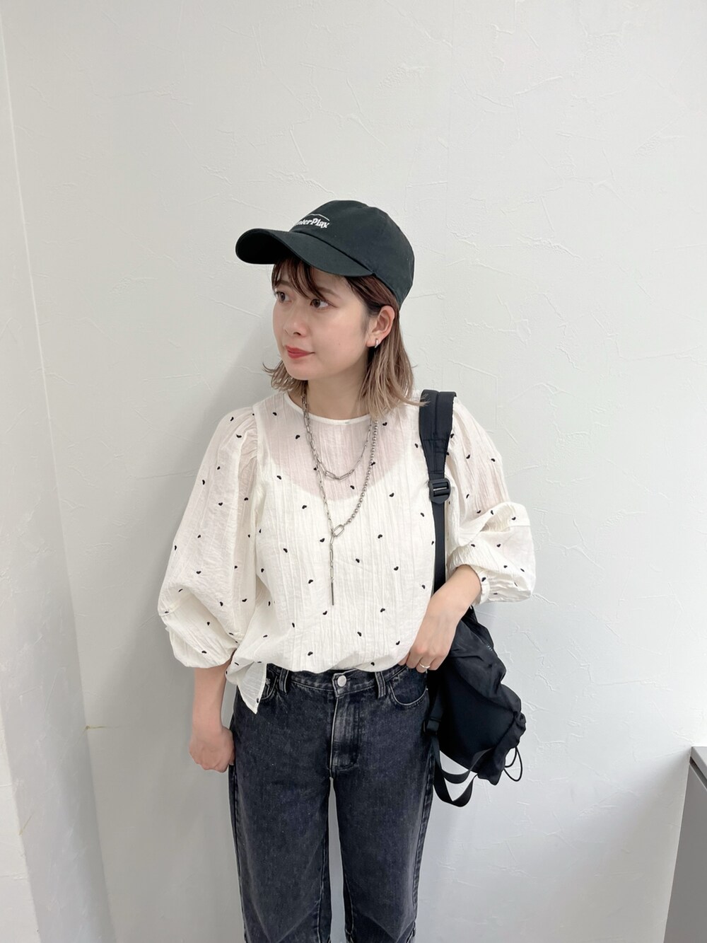ブラック系のデニムパンツ、ホワイト系のシャツ/ブラウス、ブラック系のキャップを着用したレディースの冬コーディネートの4枚目の写真