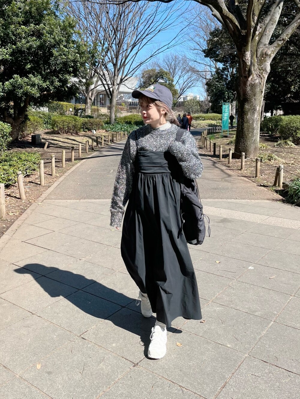 ブラック系のニット/セーター、ブラック系のバックパック/リュック、ブラック系のワンピースを着用したレディースの春コーディネートの4枚目の写真