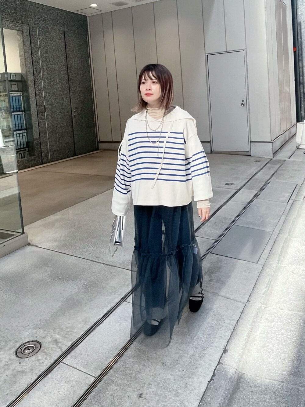 ブルー系のニット/セーター、グレー系のスカートを着用したレディースの冬コーディネートの3枚目の写真