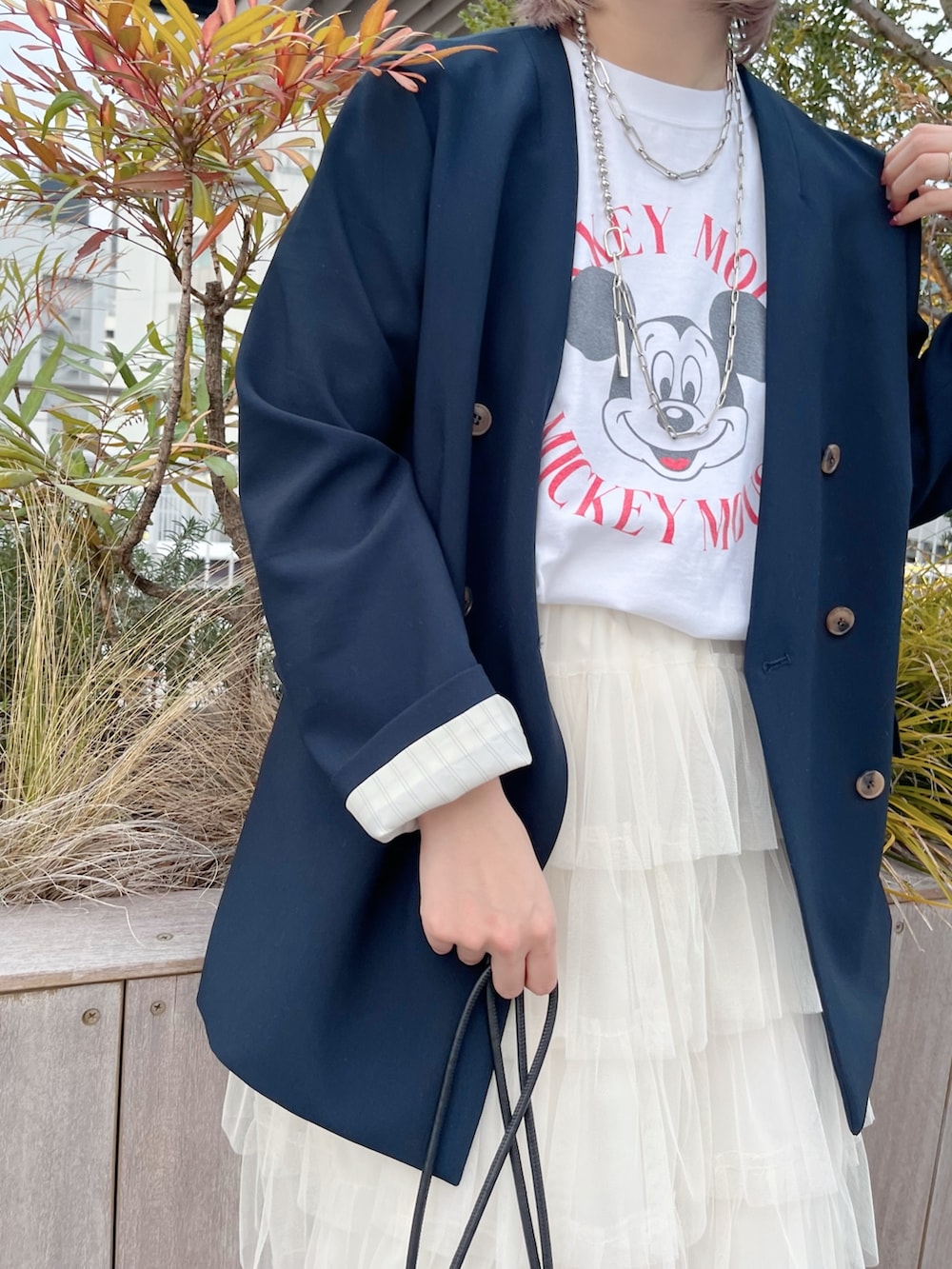 ブルー系のノーカラージャケット、ホワイト系のTシャツ/カットソー、ホワイト系のスカートを着用したレディースの冬コーディネートの4枚目の写真