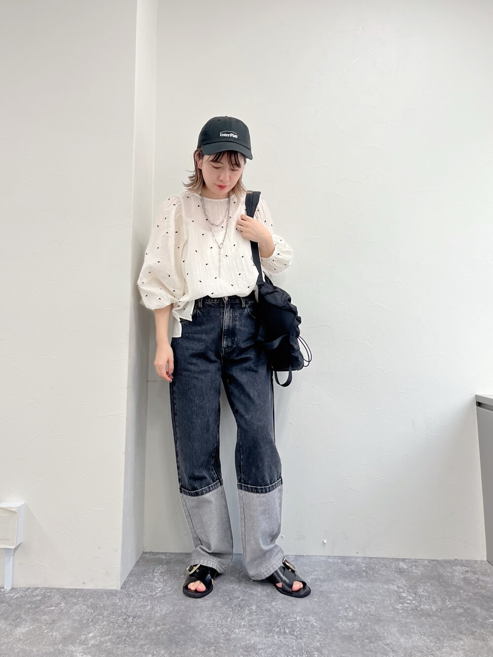ブラック系のデニムパンツ、ホワイト系のシャツ/ブラウス、ブラック系のキャップを着用したレディースの冬コーディネートの5枚目の写真