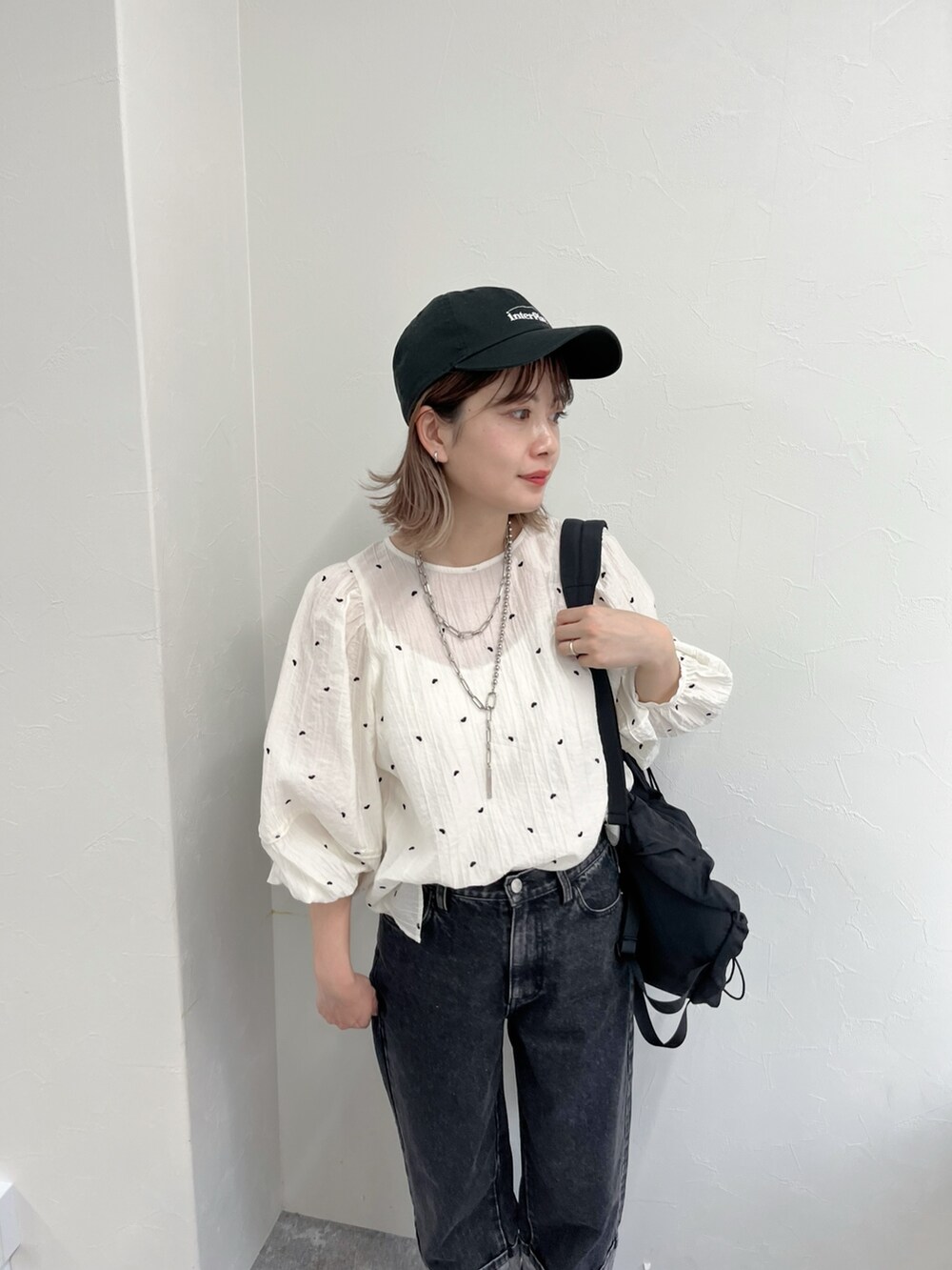 ブラック系のデニムパンツ、ホワイト系のシャツ/ブラウス、ブラック系のキャップを着用したレディースの冬コーディネートの6枚目の写真