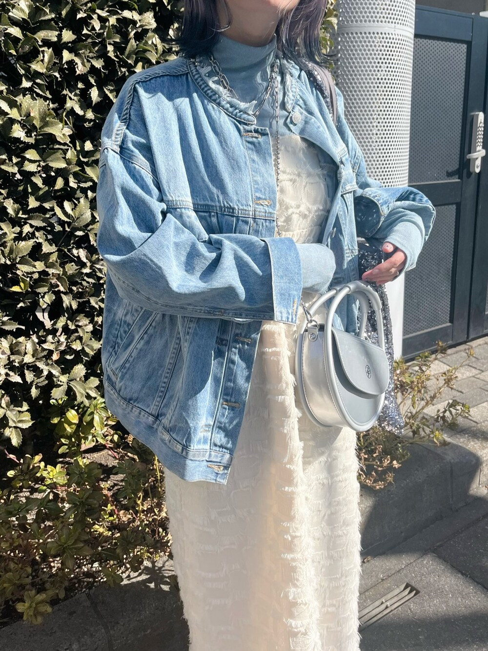 ブルー系のデニムジャケット、ホワイト系のワンピース、ブルー系のTシャツ/カットソーを着用したレディースの春コーディネートの5枚目の写真