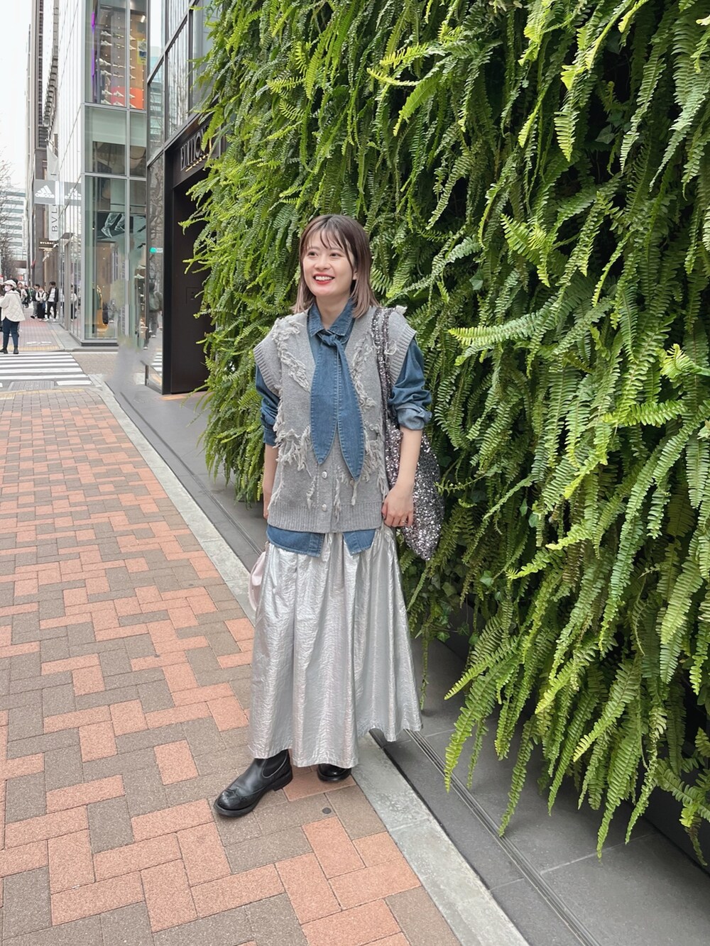 ブルー系のシャツ/ブラウス、グレー系のベストを着用したレディースの冬コーディネートの2枚目の写真