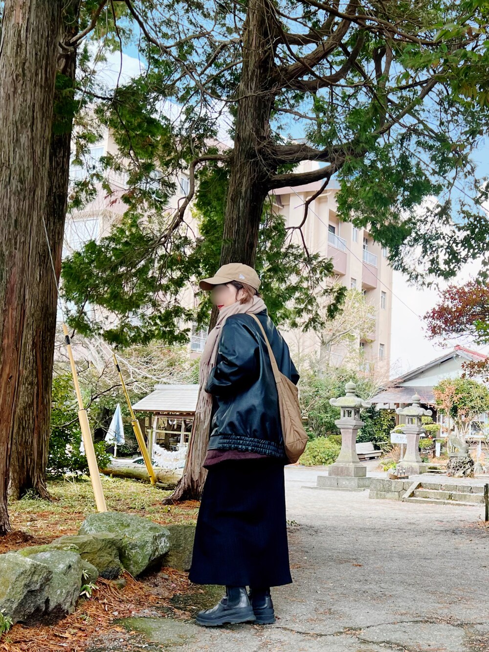 ブラック系のジャケット/アウター、ブラック系のワンピース、ベージュ系のキャップを着用したレディースの冬コーディネートの2枚目の写真