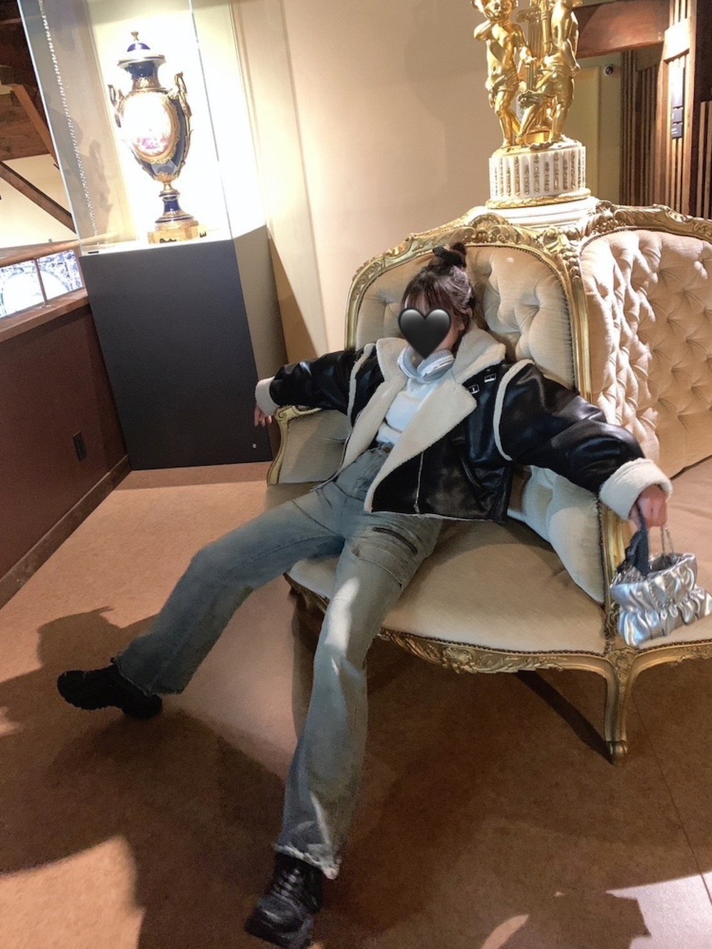 ブラック系のムートンコートを着用したレディースの春コーディネートの2枚目の写真