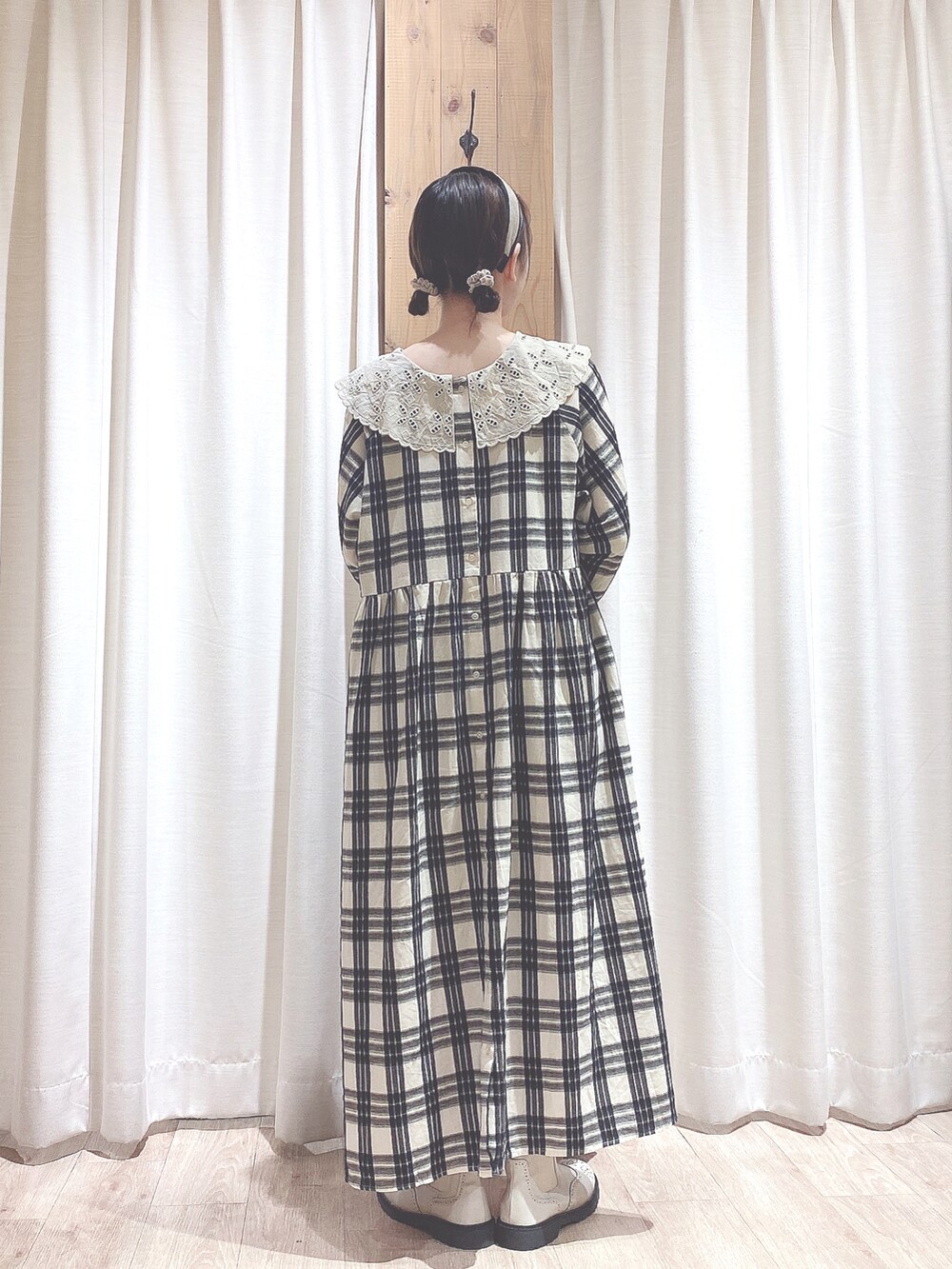 ブラック系のハンドバッグ、ホワイト系のワンピース、ホワイト系のブーツを着用したレディースの秋コーディネートの2枚目の写真