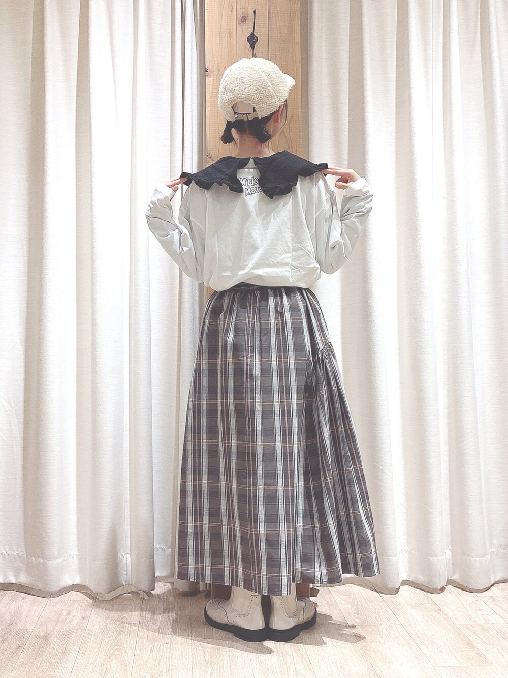 グレー系のスカート、ホワイト系のブーツ、ホワイト系のTシャツ/カットソーを着用したレディースの秋コーディネートの2枚目の写真