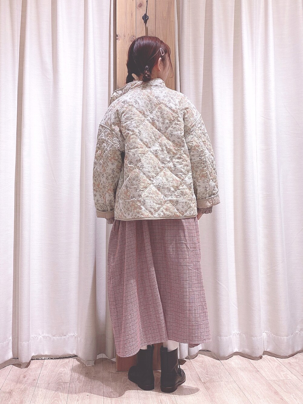 ベージュ系のノーカラージャケット、レッド系のワンピース、ブラック系のブーツを着用したレディースの冬コーディネートの2枚目の写真