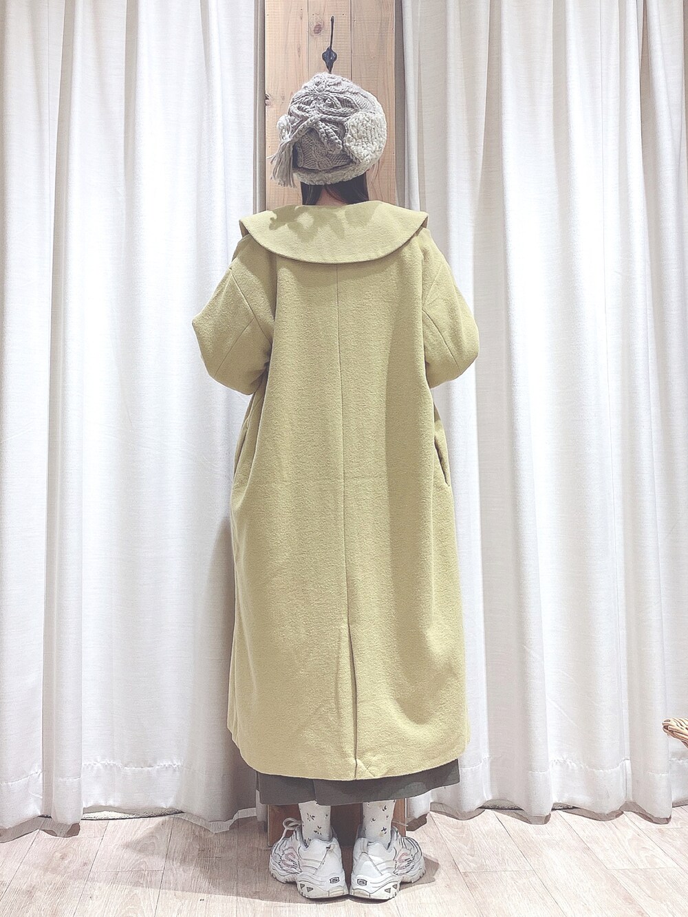 ホワイト系のスニーカー、イエロー系のその他アウター、グリーン系のワンピースを着用したレディースの冬コーディネートの2枚目の写真