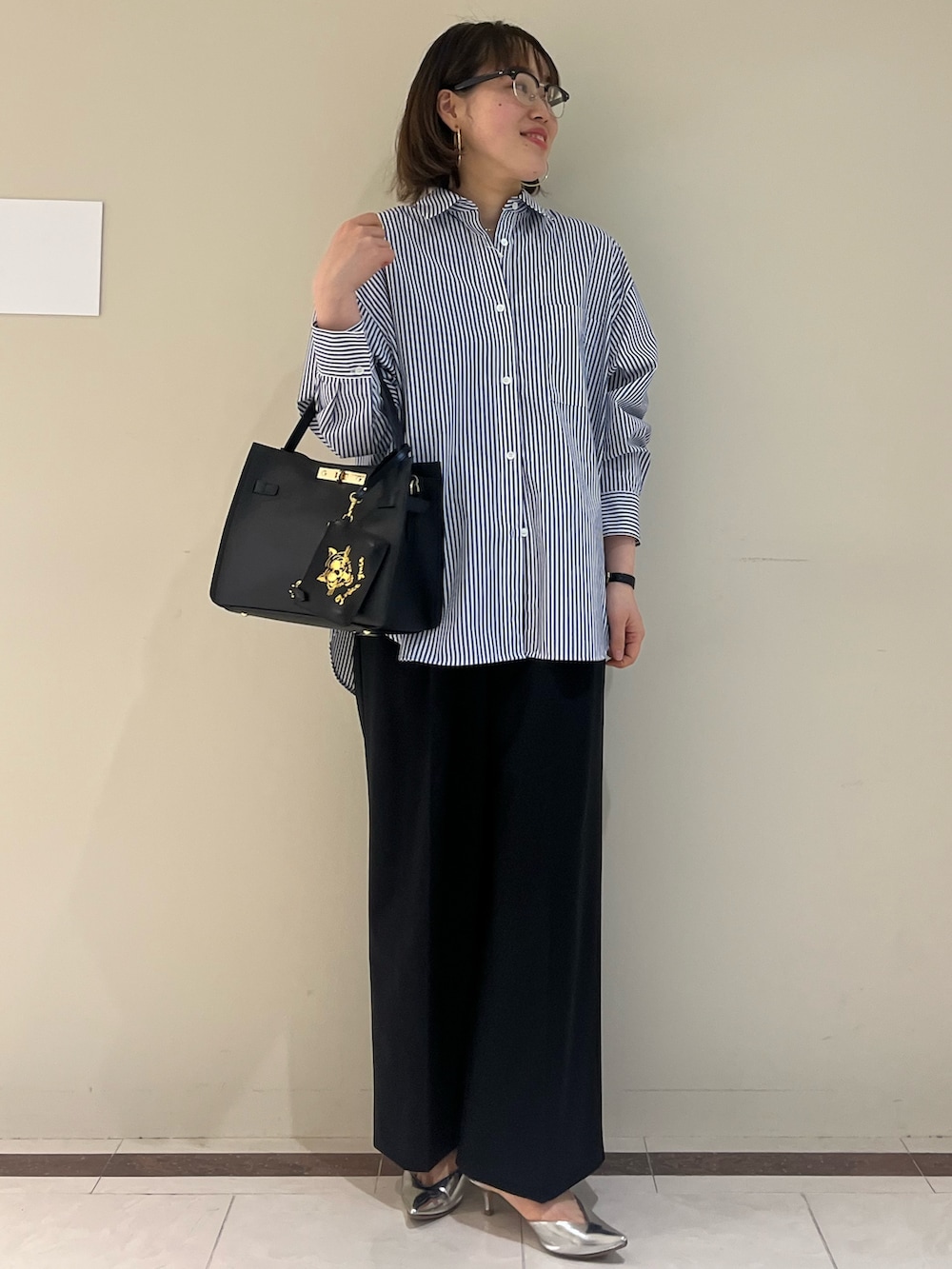 ブラック系のその他パンツ、ブルー系のシャツ/ブラウス、ブラック系のショルダーバッグを着用したレディースの春コーディネートの4枚目の写真