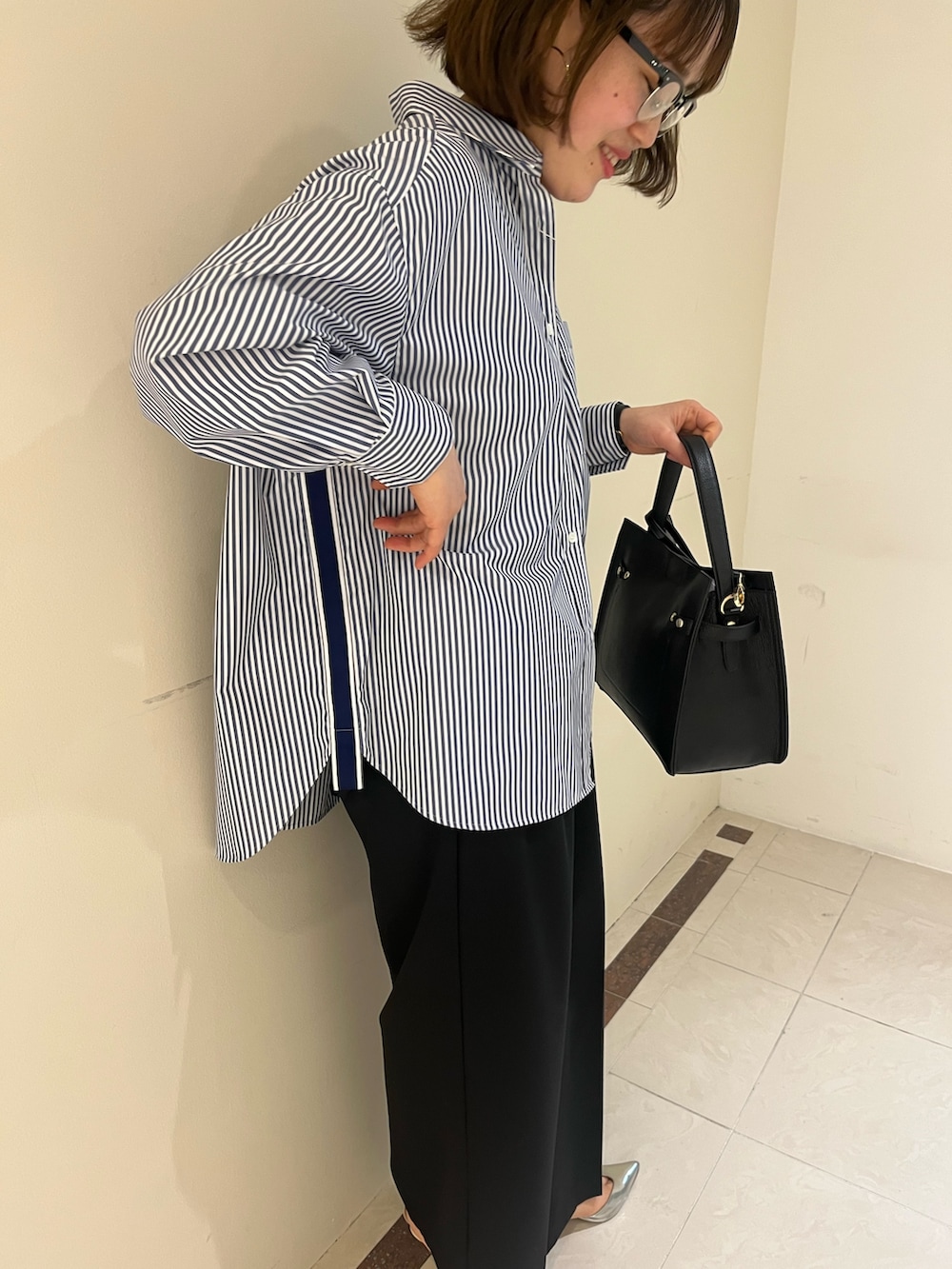 ブラック系のその他パンツ、ブルー系のシャツ/ブラウス、ブラック系のショルダーバッグを着用したレディースの春コーディネートの10枚目の写真