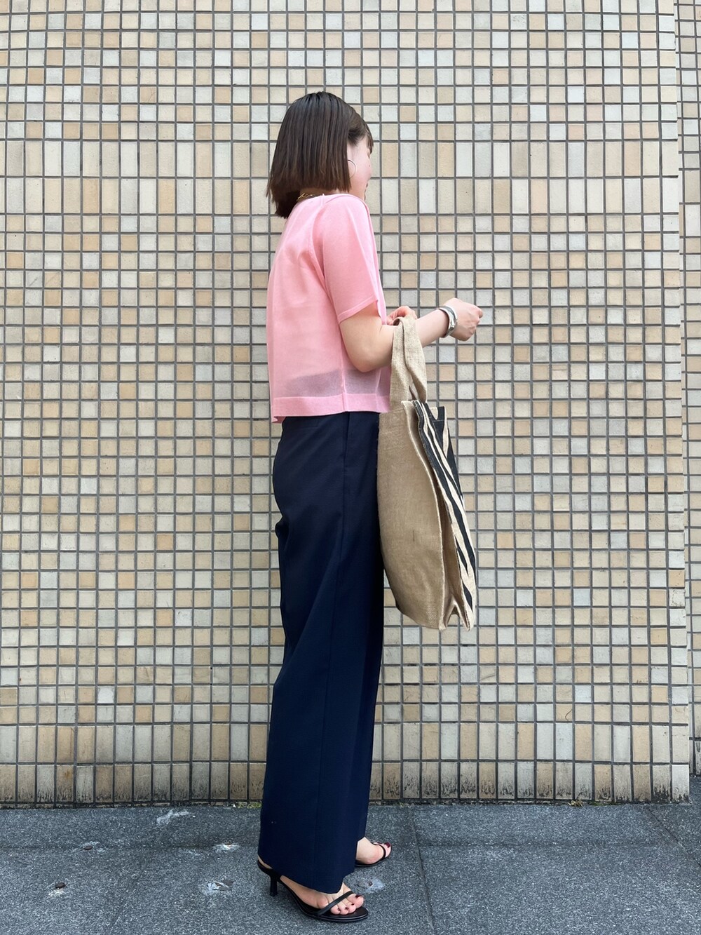 ピンク系のニット/セーター、ブルー系のその他パンツ、その他のトートバッグを着用したレディースの春コーディネートの3枚目の写真