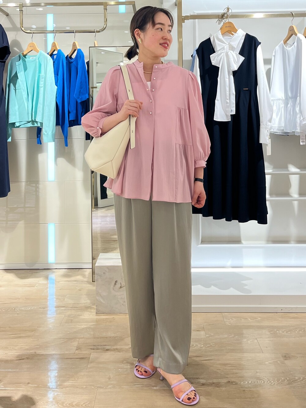 ベージュ系のその他パンツ、ホワイト系のタンクトップ、ホワイト系のショルダーバッグを着用したレディースの春コーディネートの7枚目の写真