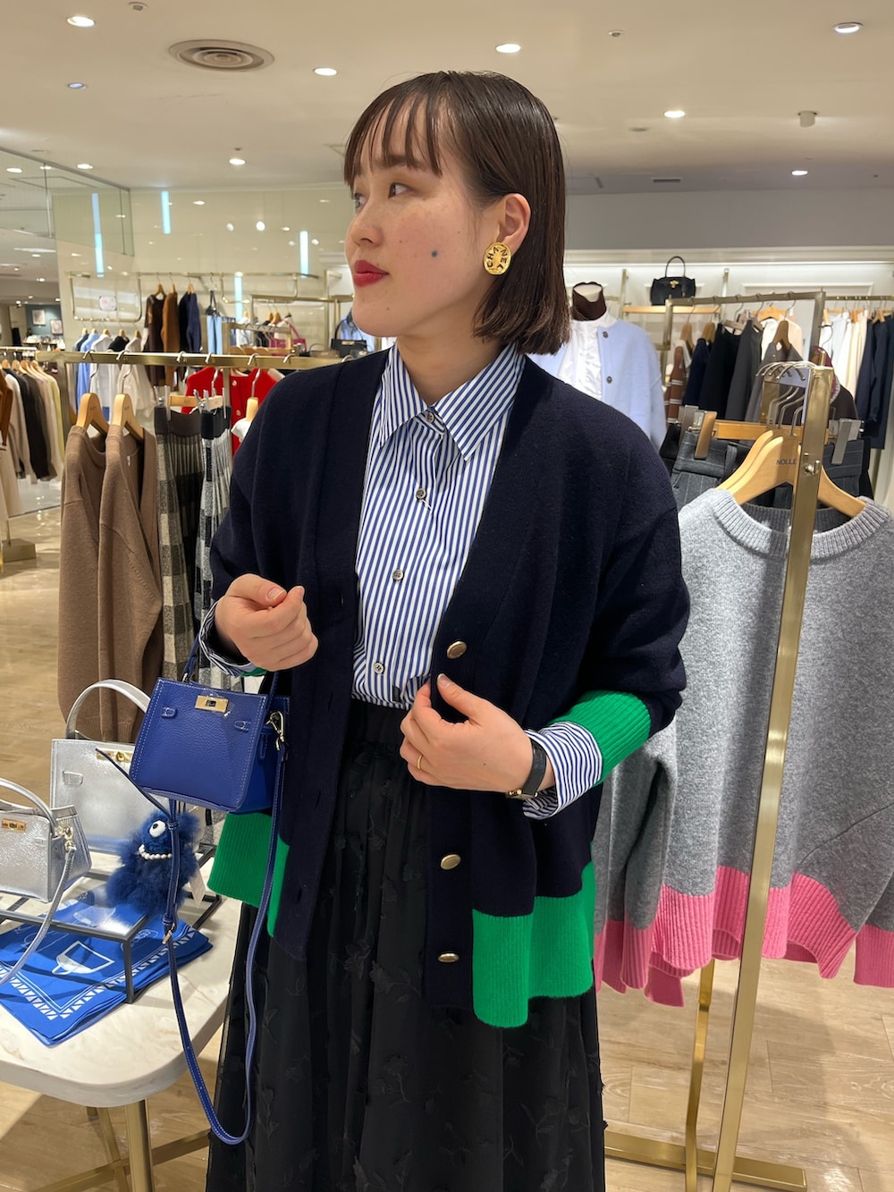 ブルー系のショルダーバッグ、ブルー系のカーディガン/ボレロ、ブルー系のシャツ/ブラウスを着用したレディースの秋コーディネートの9枚目の写真